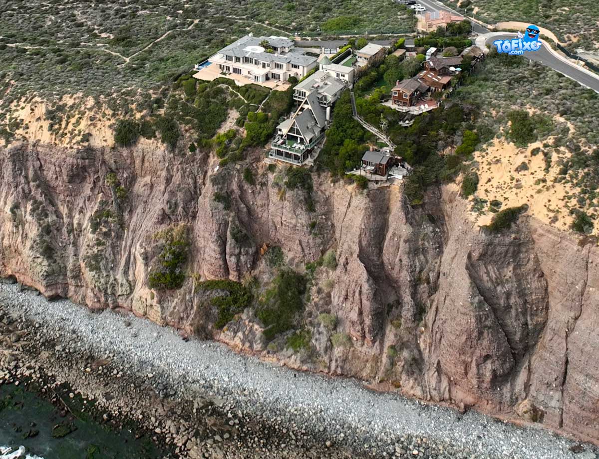 Casas na praia em risco de derrocada depois de deslizamento de terra
